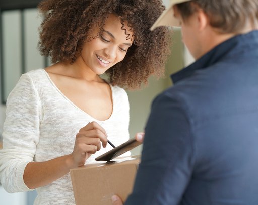 Mixed race woman receiving package from delivery man